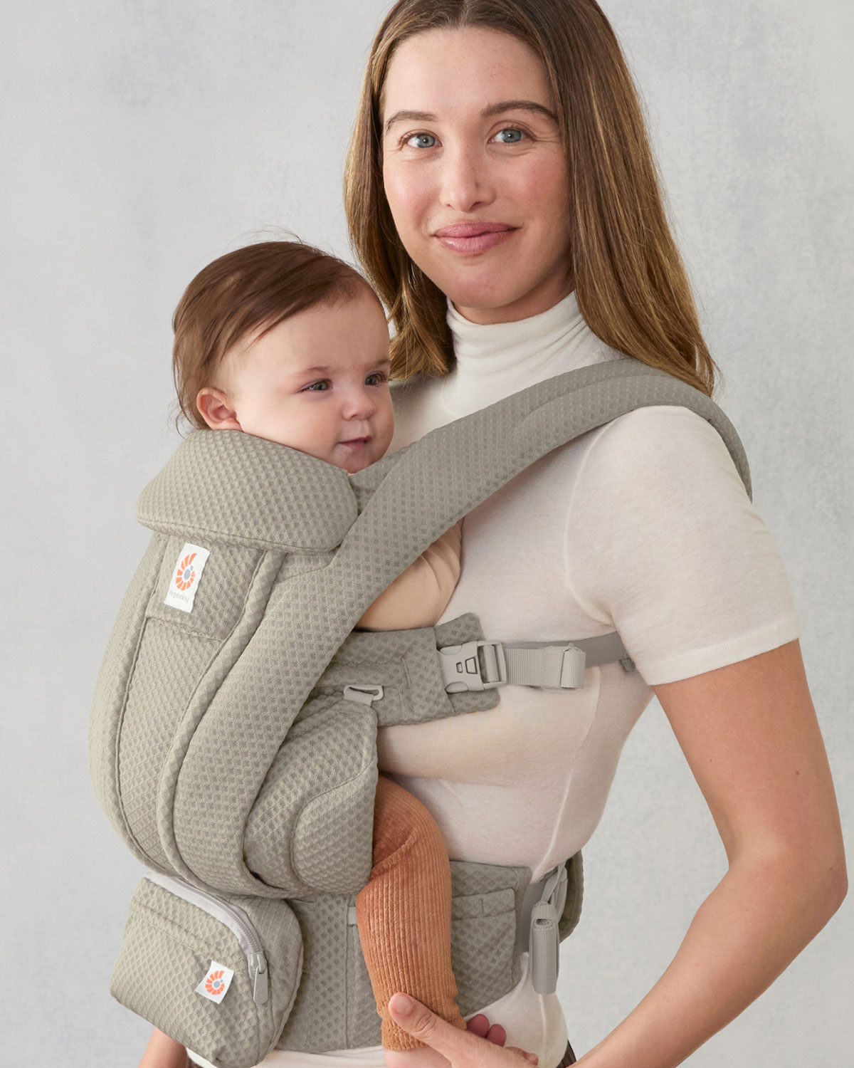 Persona porteando a su bebé en un portabebés Ergobaby