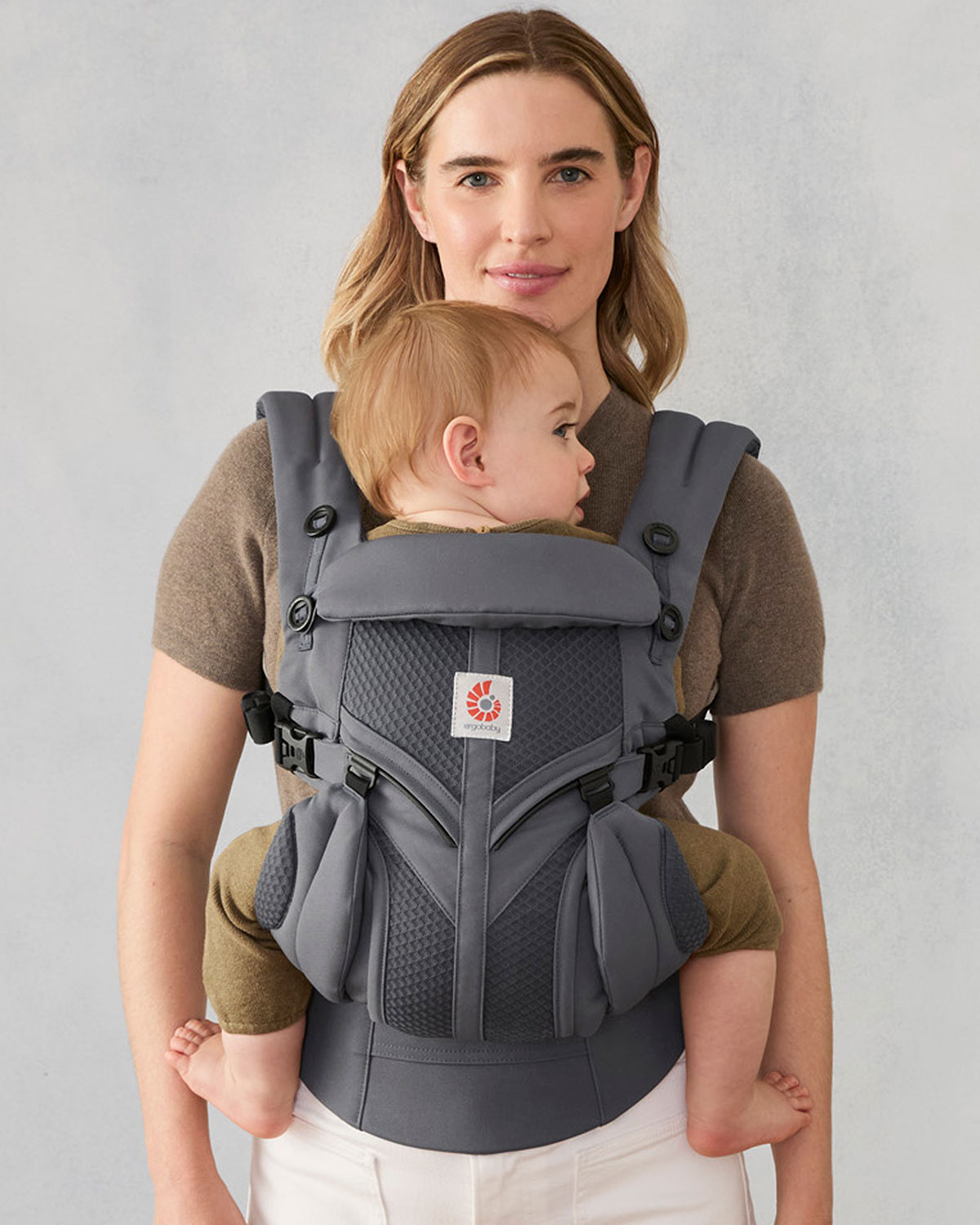 Persona llevando a su bebé en un portabebés Ergobaby con soporte de muslos